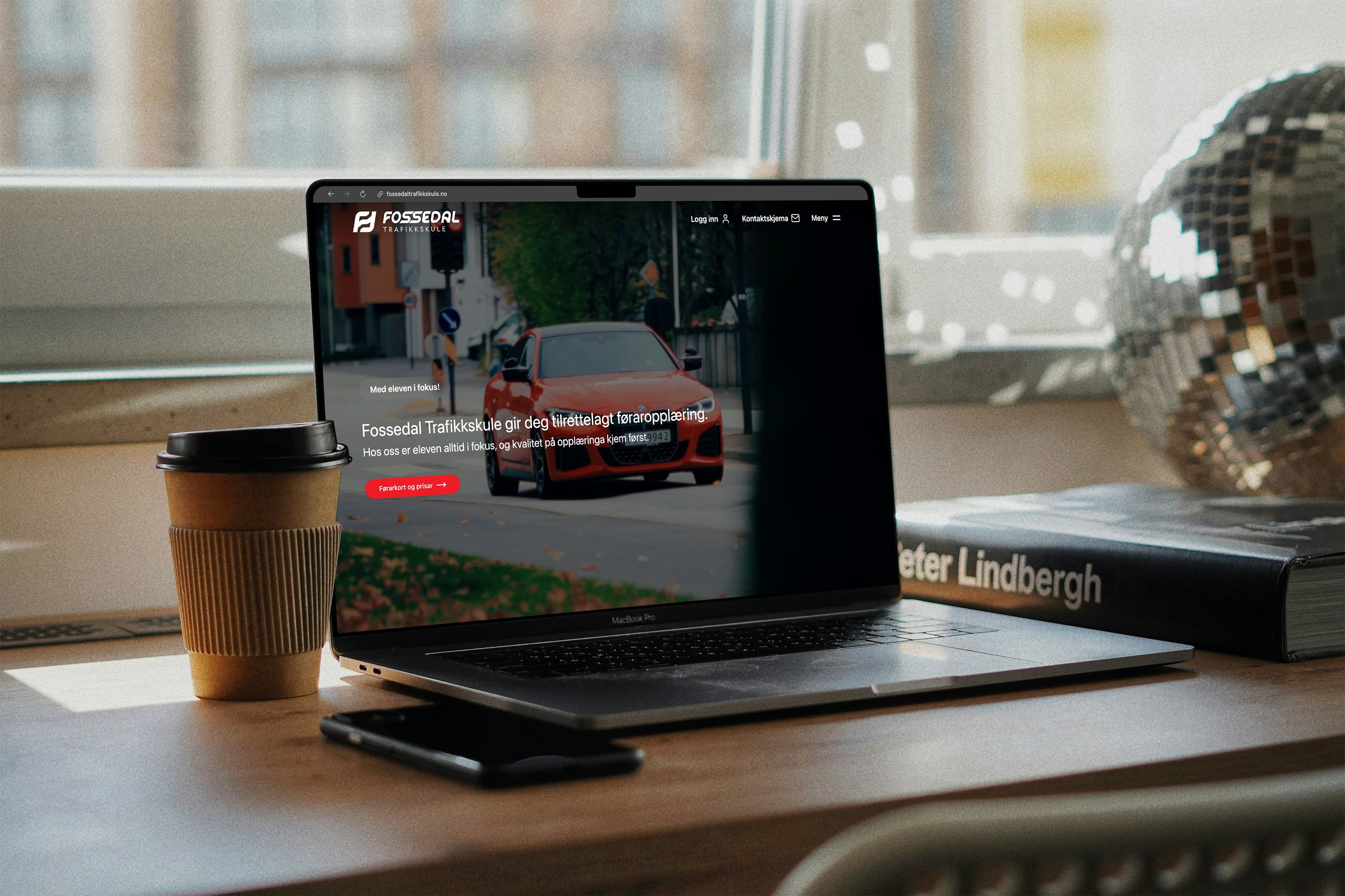 Berbar datamaskin på eit skrivebord som viser framsida til Fossedal Trafikkskule